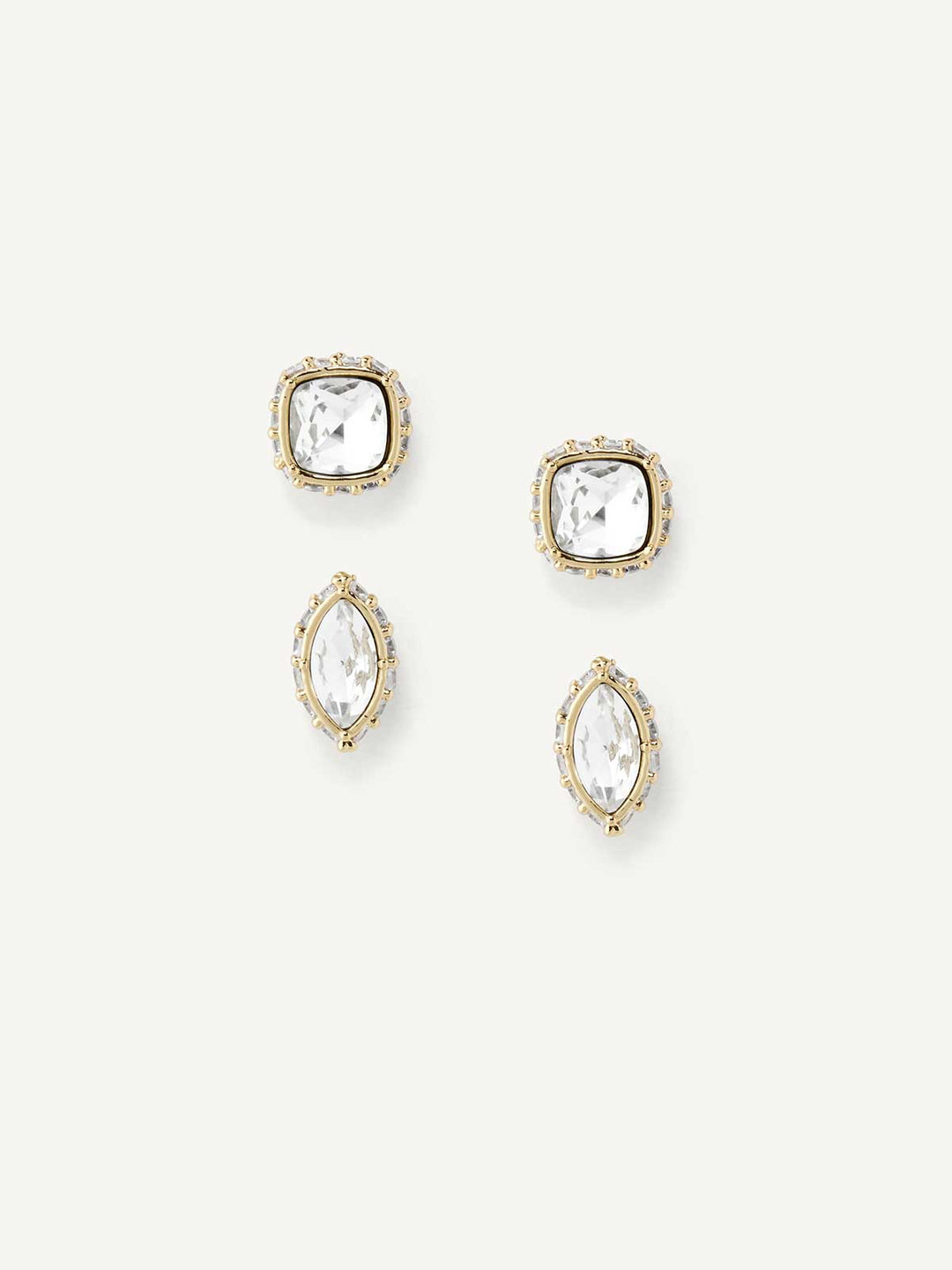 Set of gold and crystal stud earrings on a white background