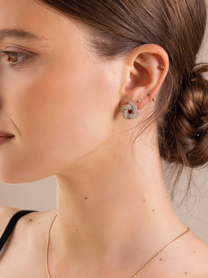Close-up of a woman wearing a decorative earring with a neutral background