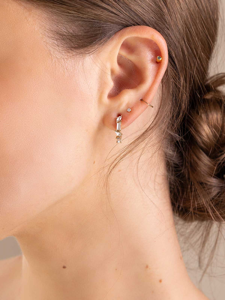 Close-up of an ear with gold hoop earrings